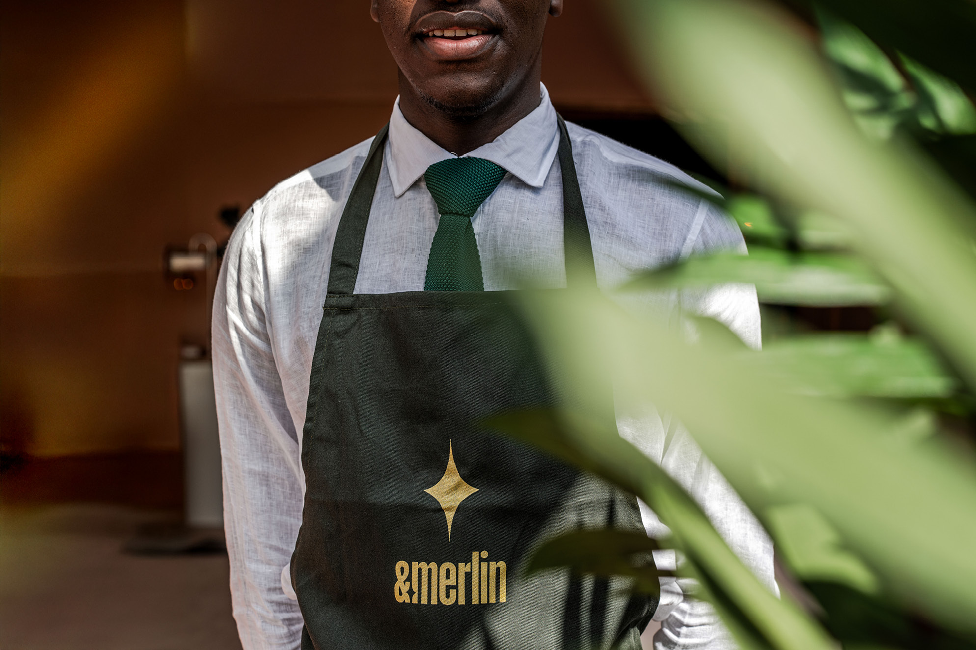 &merlin event staff in a branded apron, branding by Supermoon