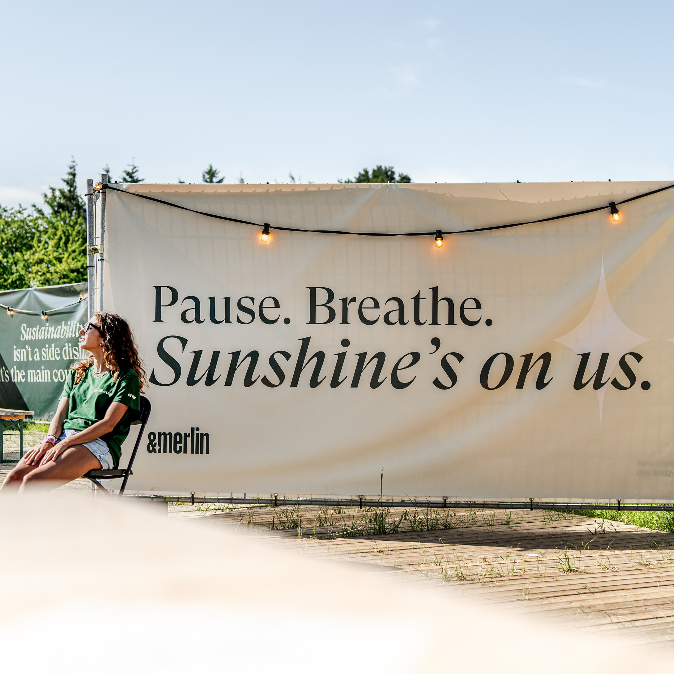 &merlin outdoor event banner: pause, breathe, sunshine's on us