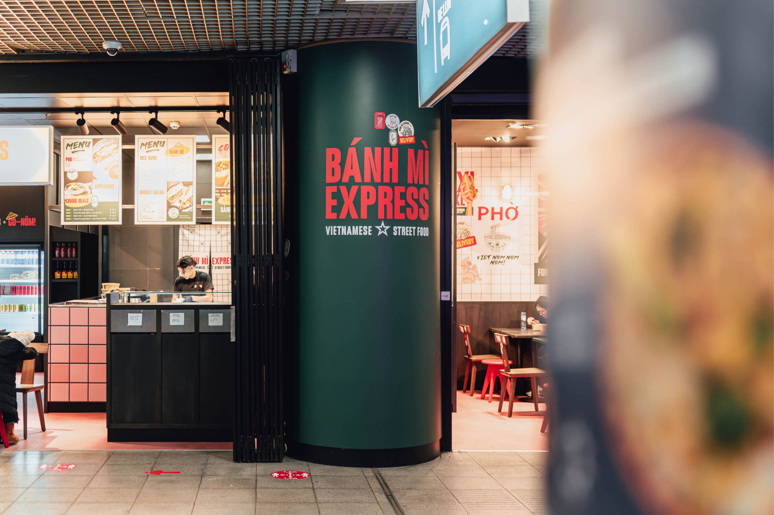 Banh Mi Express restaurant interior with branded column and menu boards