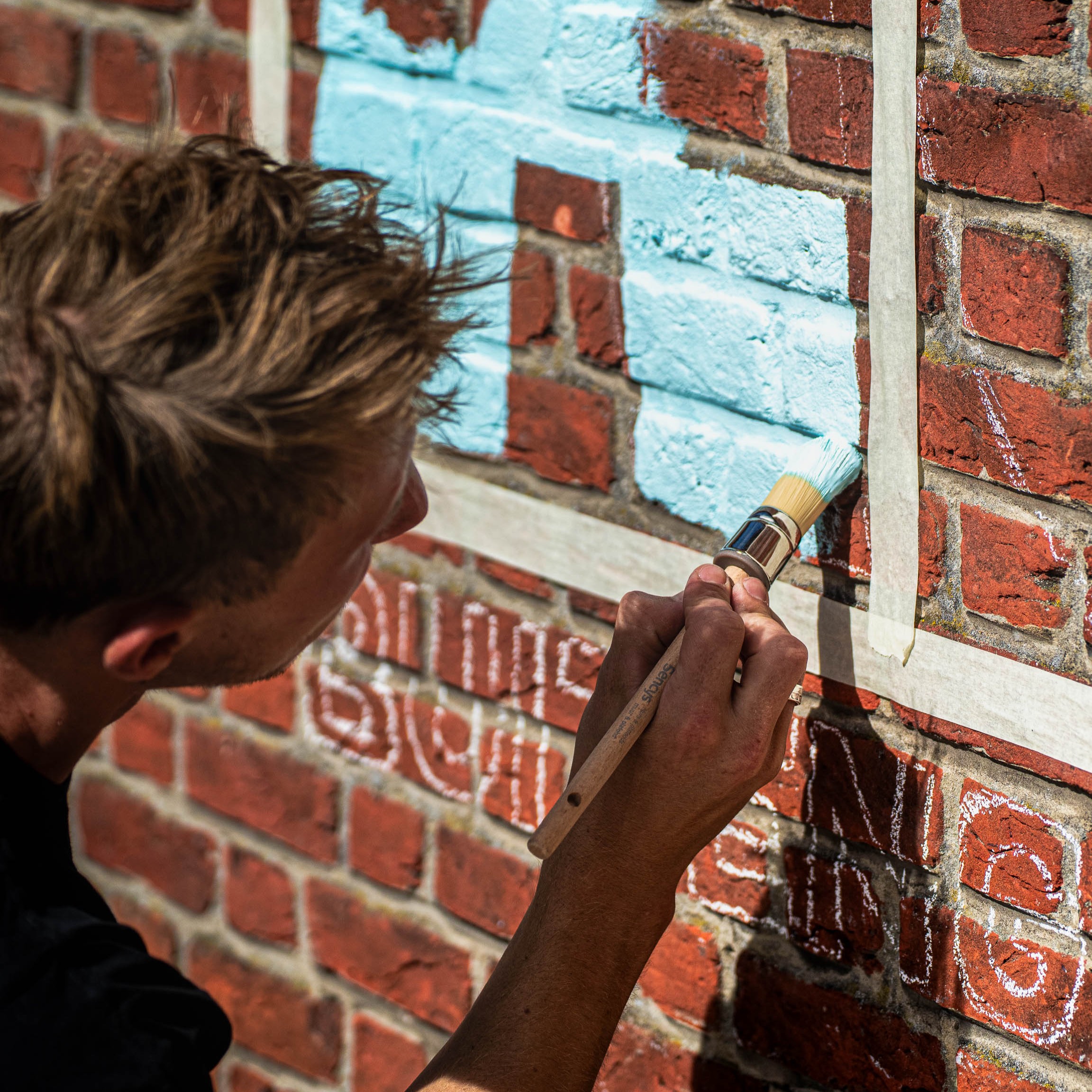 Painting the De Achterdeur logo on the entrance wall